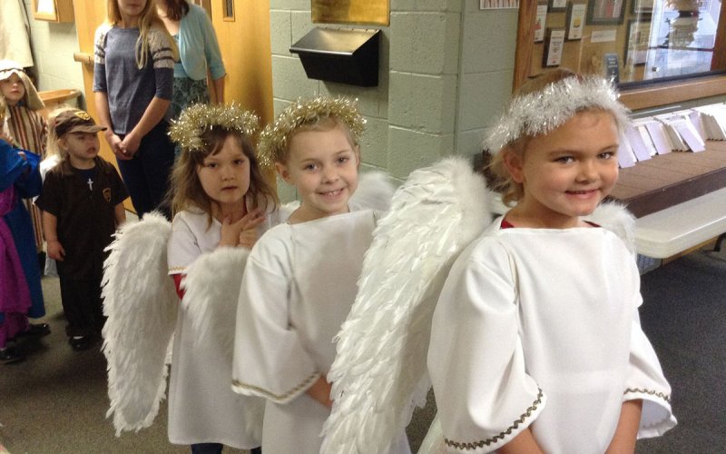 Centenary youth dressed as angels for a Christmas presentation